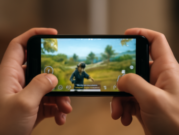 Pemain memegang HP kecil secara horizontal saat memainkan game battle royale
